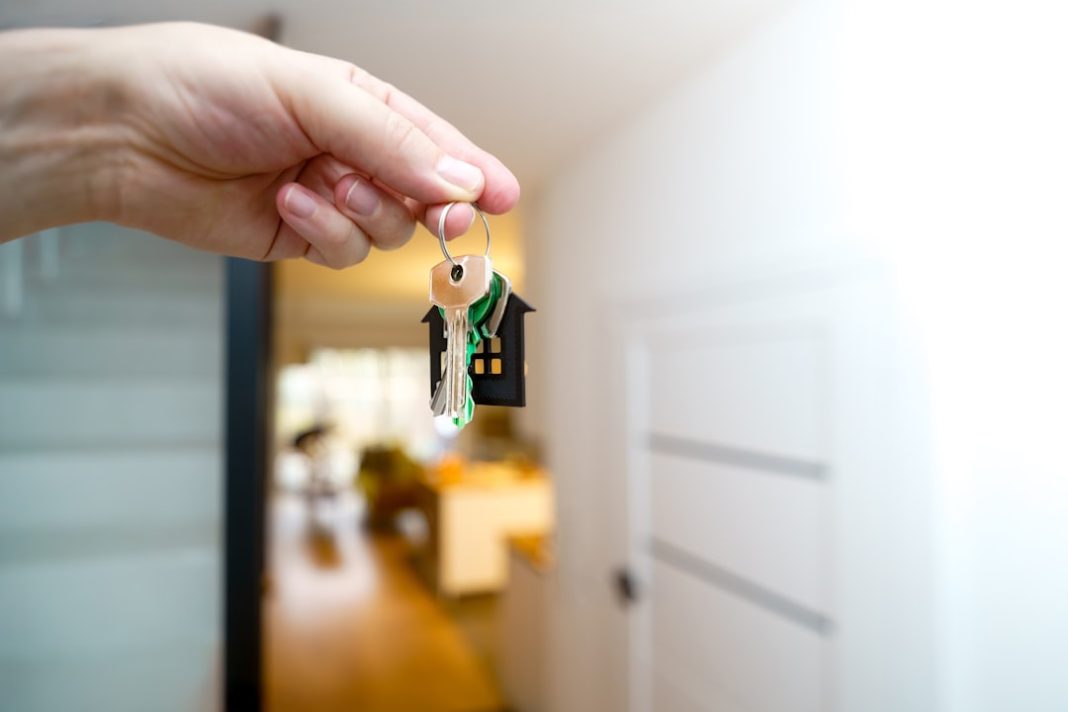 Holding house keys in front of the entrance.