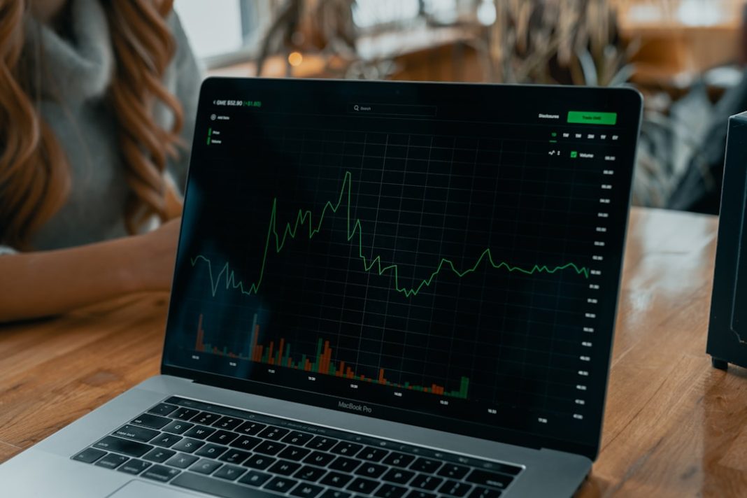 laptop showing stock chart on desk