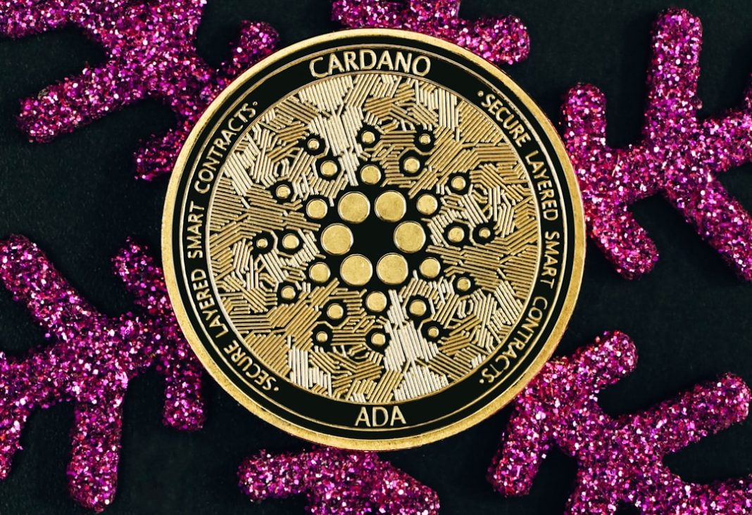 a pink and gold brooch sitting on top of a black surface