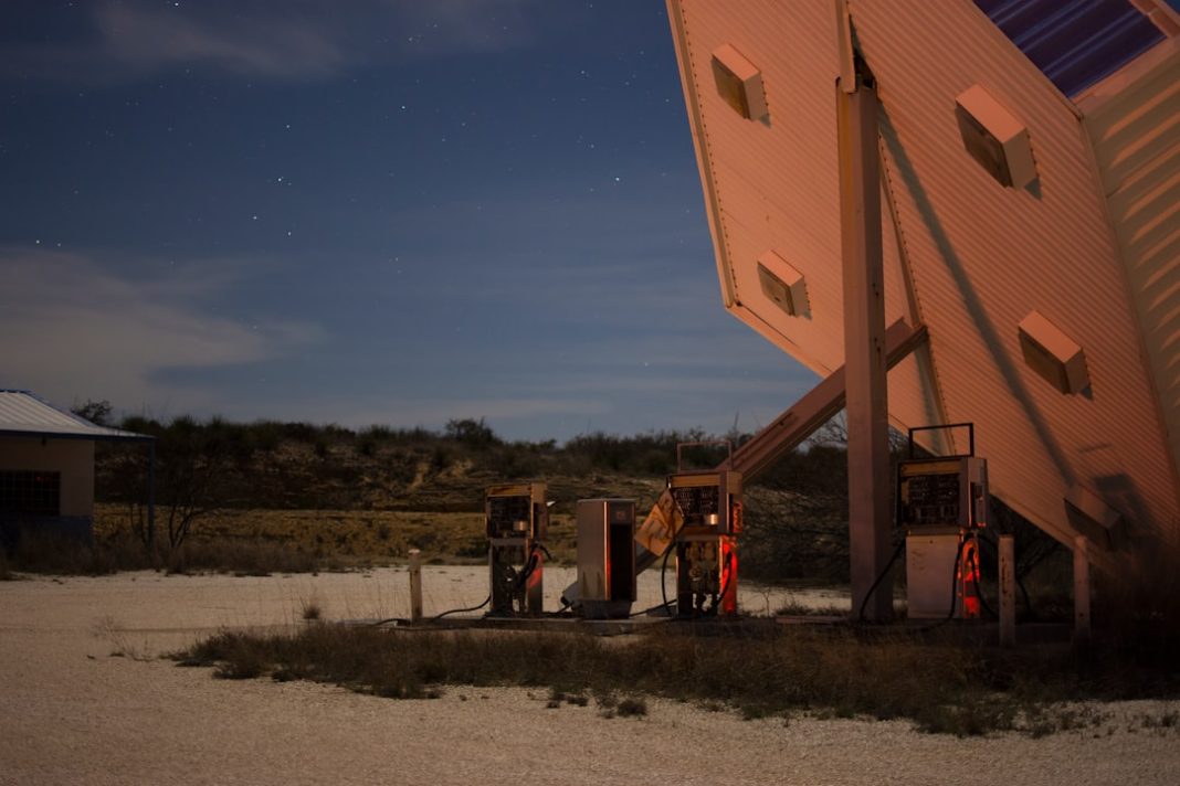 a gas station at night with the moon in the sky